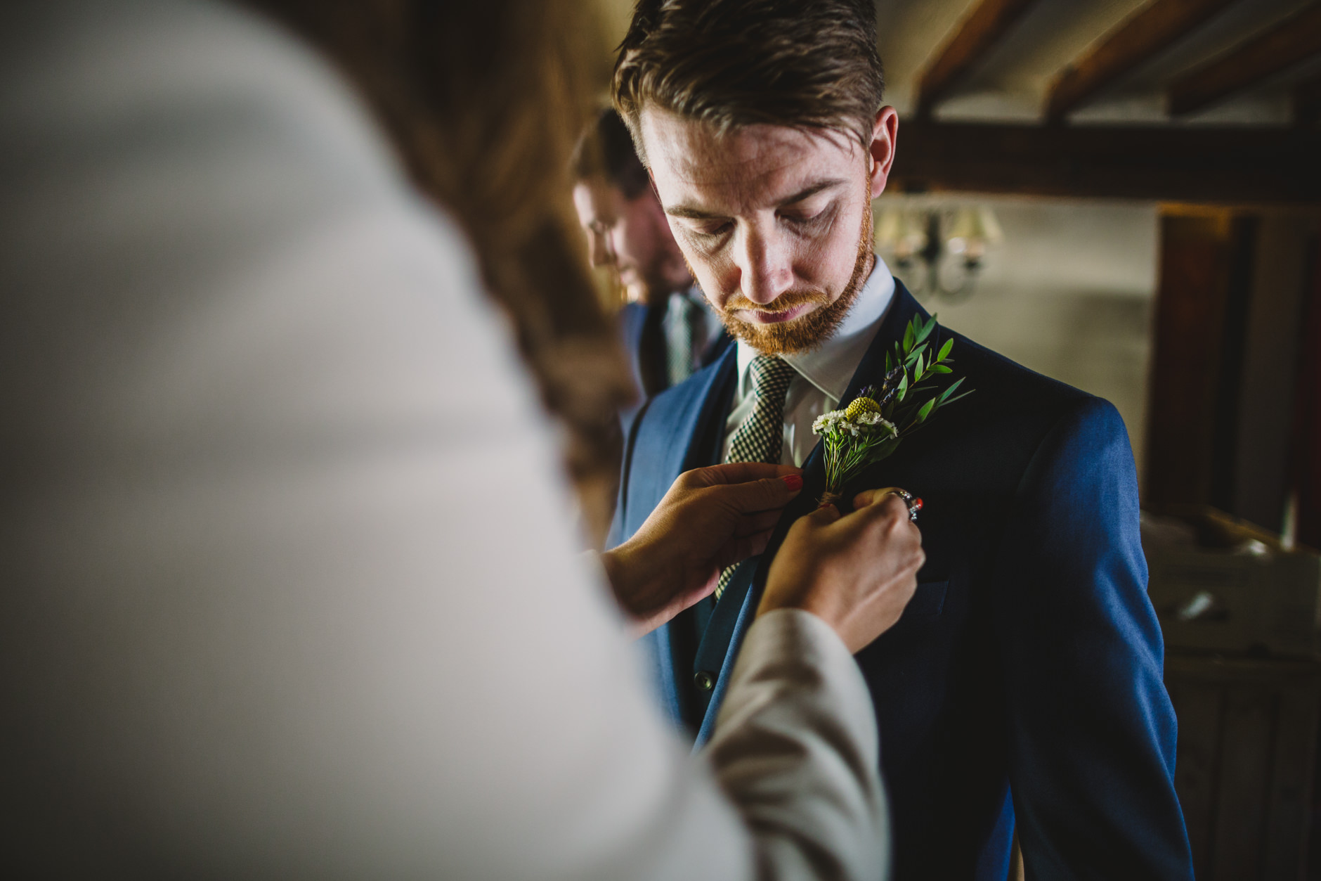 groom having his button hole flower pinned into position