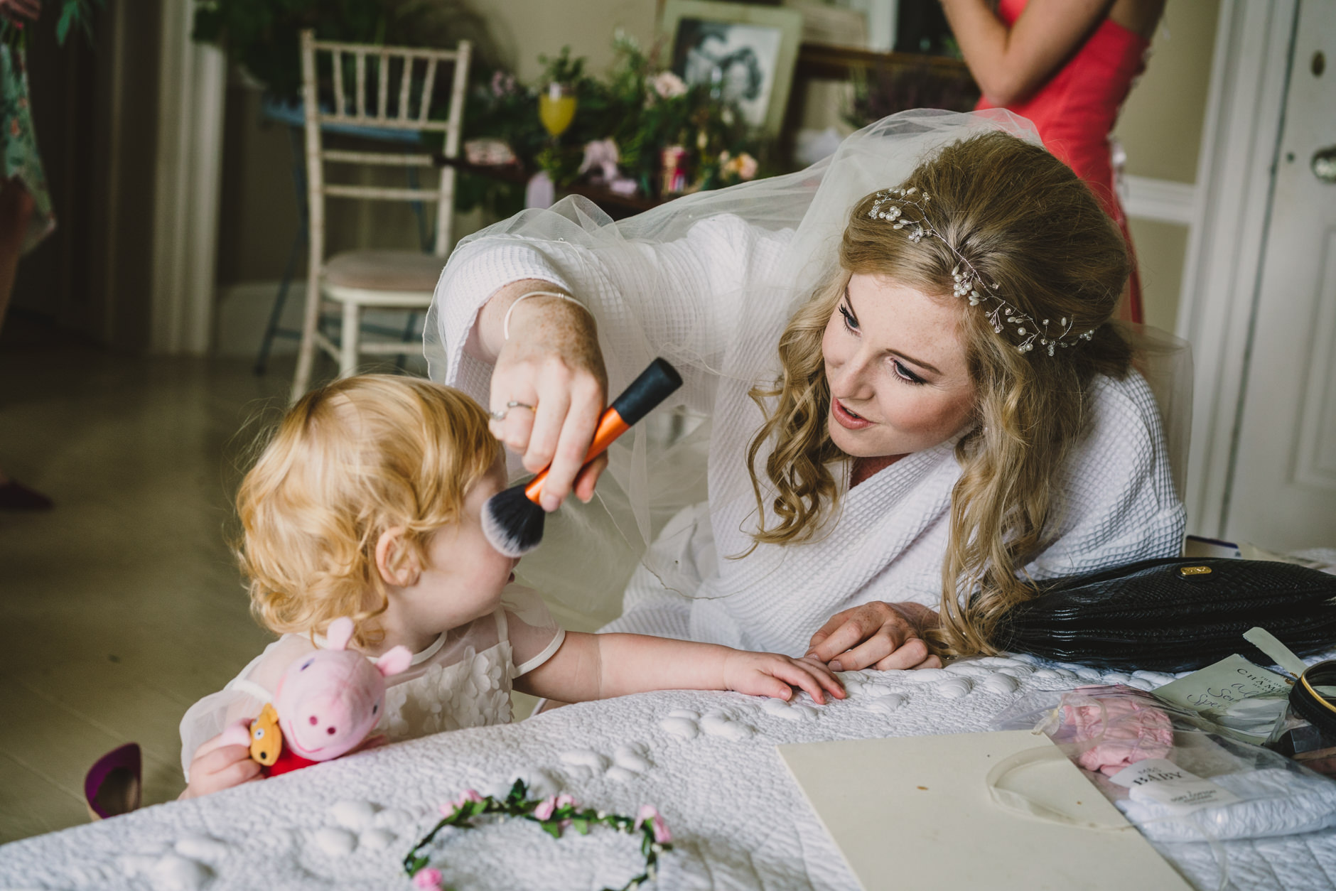 bride pretending to put make up on the flower girl at east bridgford hill
