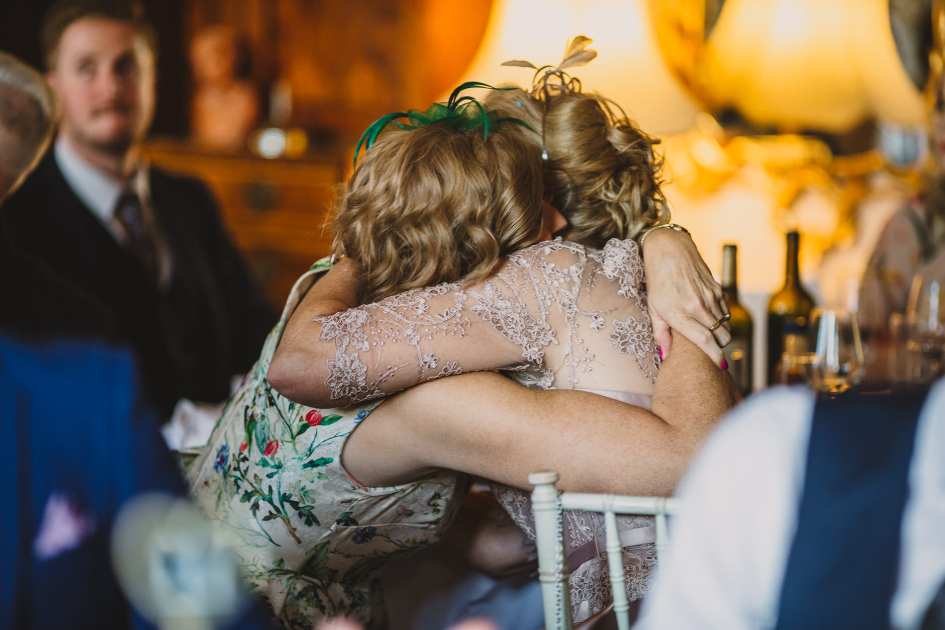 mother of the groom and her twin sister shae an embrace during wedding reception