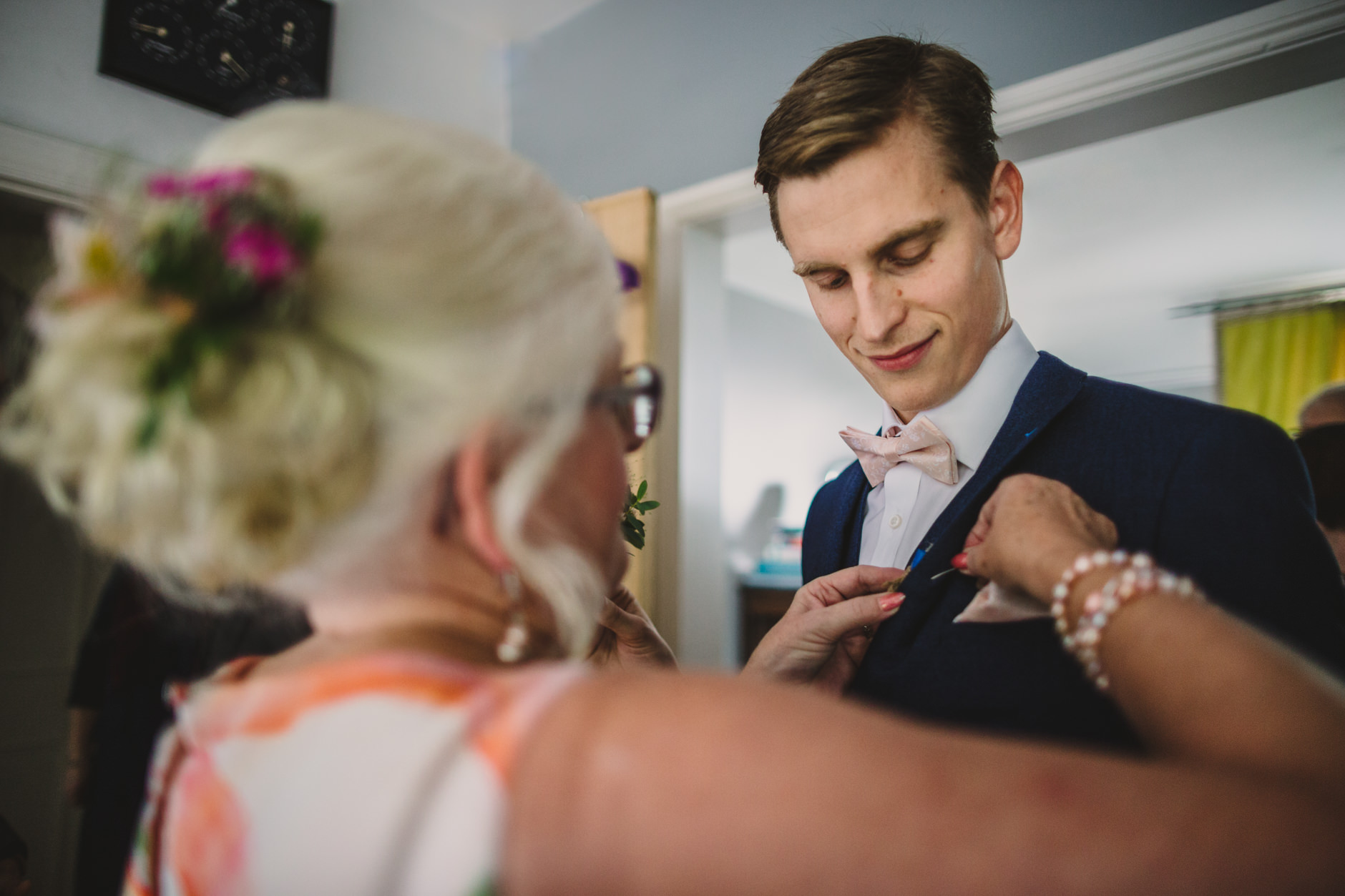 mother of the groom helps her son to get ready for his wedding day
