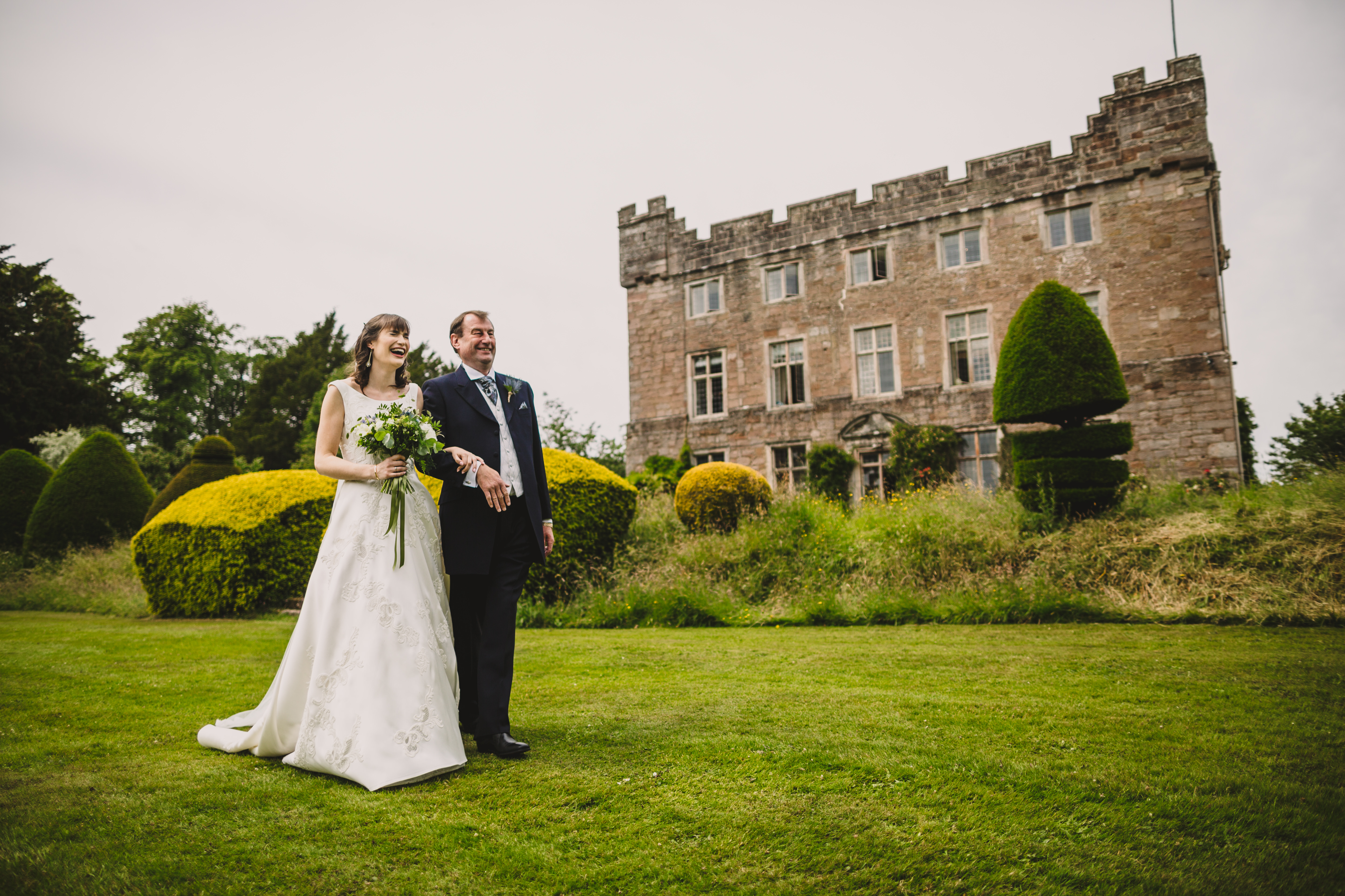 bride and father walking to outdoor ceremony at askham hall