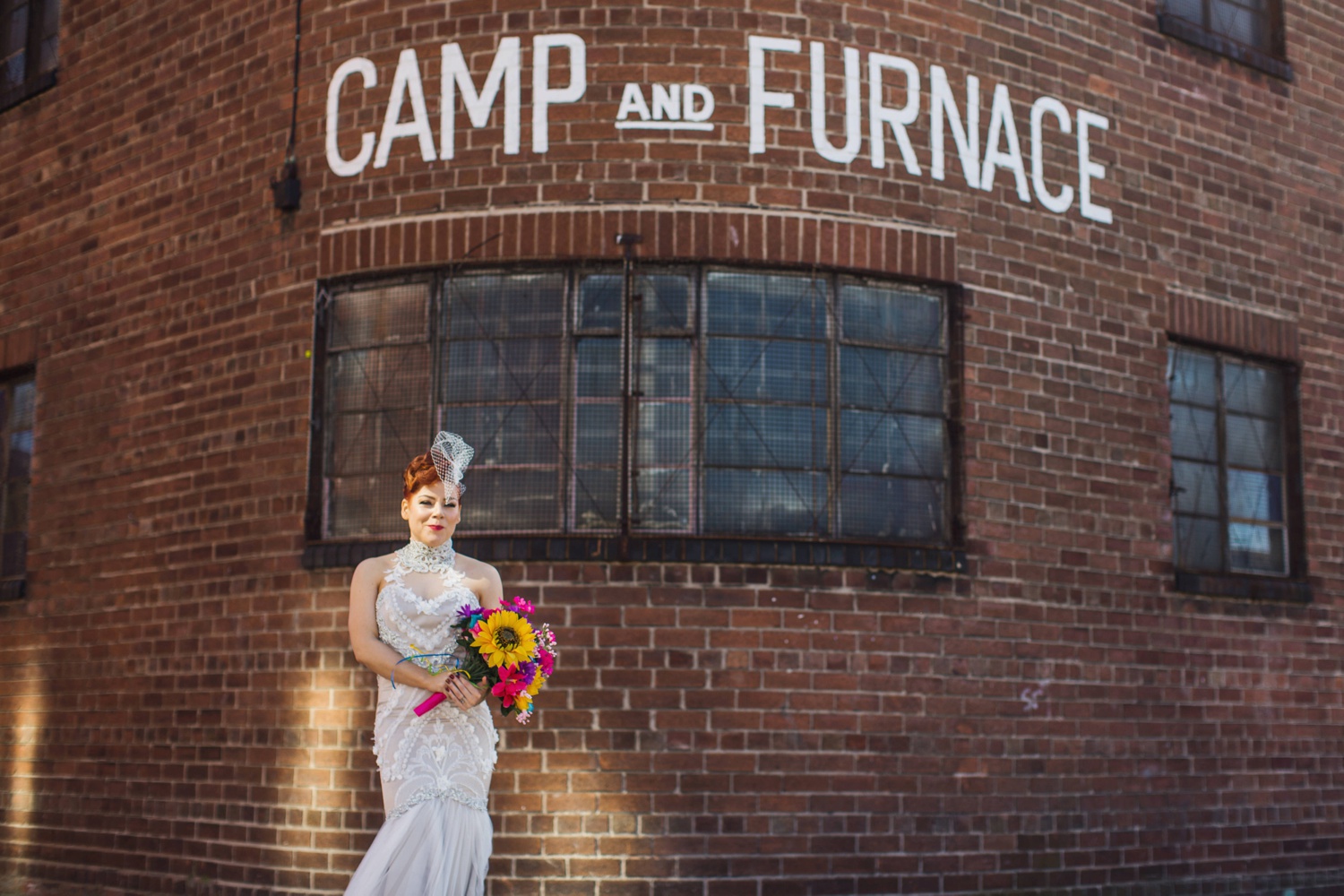 Vintage inspired bride in front of Camp and Furnace sign