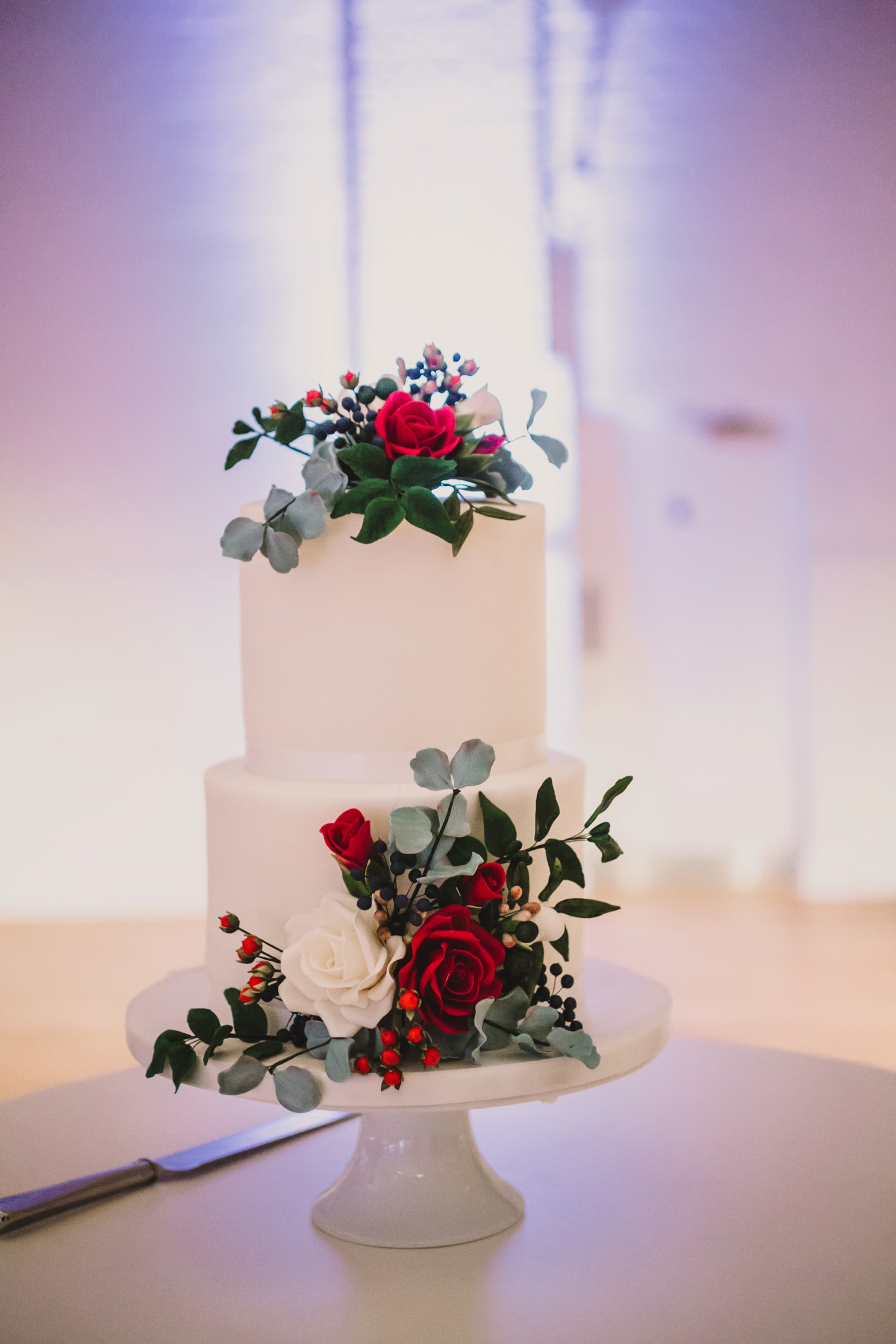 Wedding cake with red and white flowers holkham hall